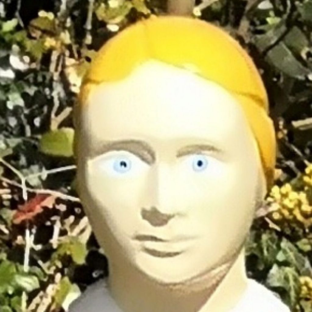 very close up picture of the face of the statue above. the face is entirely the colour of turned milk - a creamy white. It has painted primary yellow coloured hair, and no eyebrows or lashes. the eyes are ice blue, with unmatched pupils.
